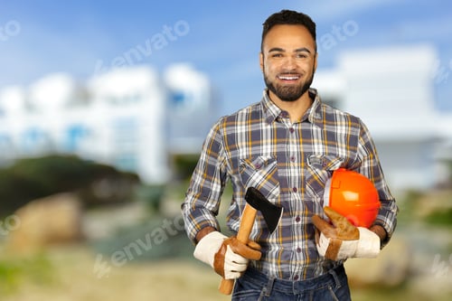 Preview: Construction worker smiles while holding tools and wearing safety gear outdoors in bright sunlight
