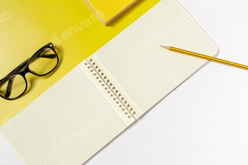 Preview: Notepad and glasses on a yellow desk with a pencil ready for writing tasks
