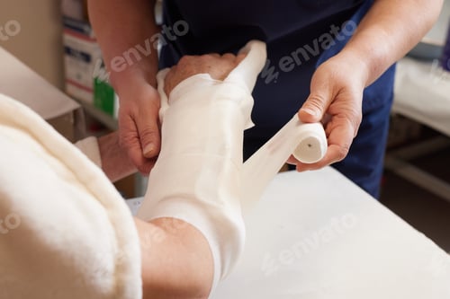 Preview: doctor puts a plaster on the arm of a patient in the hospital with a broken arm