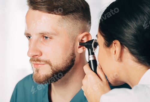 Preview: man getting medical ear exam at clinic. Audiologist Examining male patient ear , using otoscope