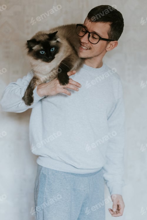 Preview: Boy with grey clothes holding his cat on his shoulders