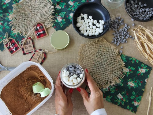 Preview: Woman crafting making chocolate mix with marshmallows and mini chocolate chips for Christmas gifts