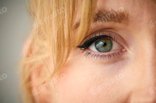 Preview: Close Up Studio Shot Of Woman's Eye Looking At Camera Against Plain Studio Background