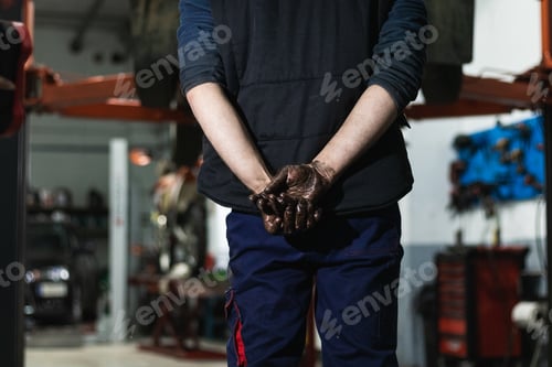 Preview: Anonymous mechanic with dirty hands behind back