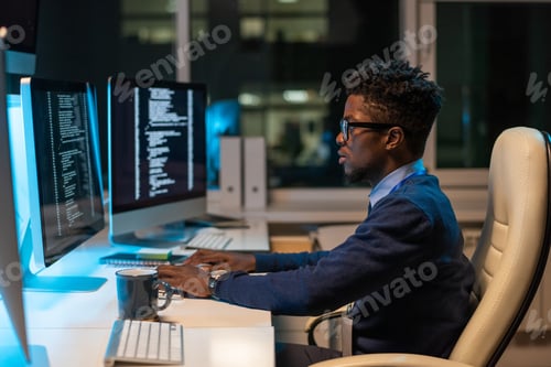 Preview: Young it-engineer of African ethnicity working in front of computer