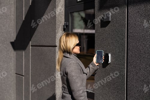 Preview: Woman hands using phone scan to digital door lock security systems at home.
