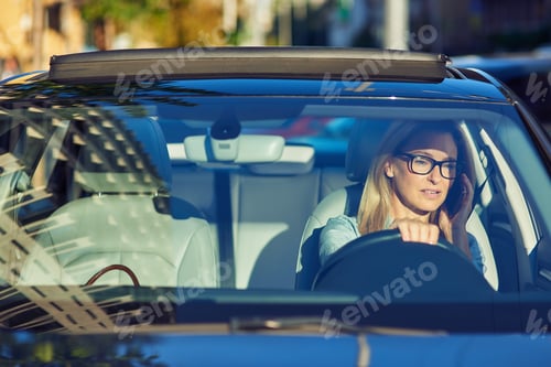 Preview: On the way to office. Focused mature business woman wearing eyeglasses talking by mobile phone
