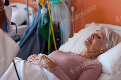 Preview: Smiling caucasian senior female patient lying in hospital bed, copy space
