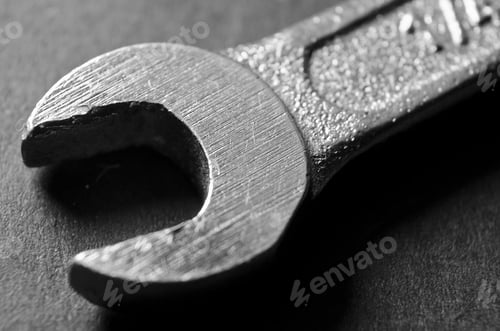 Preview: Macro grayscale shot of a metal wrench on a dark surface