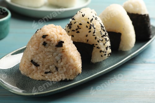 Preview: Rice balls (onigiri) on light blue wooden table, closeup. Traditional Japanese dish