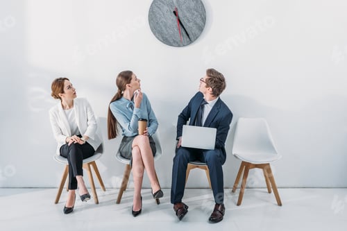 Preview: women and man with laptop looking at clock while waiting job interview