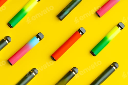 Preview: Colorful disposable electronic cigarettes on yellow background