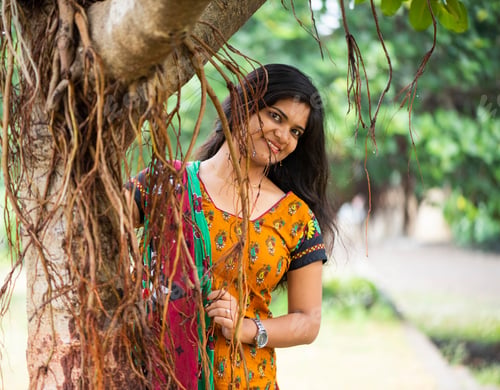 Preview: Happy woman near banyan tree