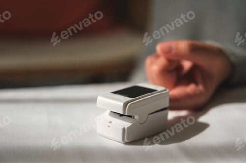 Preview: A woman using digital fingertip pulse oximeter device to measure oxygen and blood pulse rate