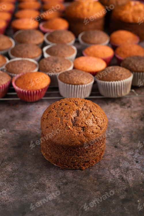 Preview: Small freshly baked cake and cupcakes in the background. Pastry table.