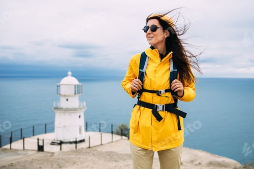 Preview: A traveler on the background of a lighthouse by the sea