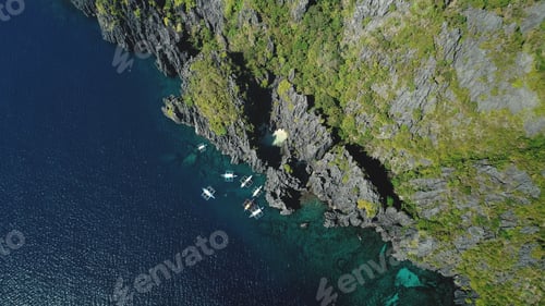 Preview: Passenger boat at cliff ocean shore at tranquil seascape aerial view. Majestic nature at rock island