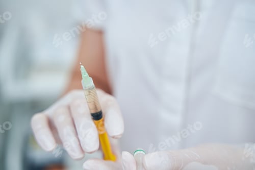 Preview: Close up of female hand demonstrating syringe