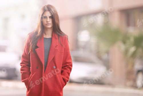 Preview: Portrait of a gorgeous young woman in a red winter coat standing in an urban setting