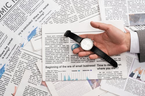 Preview: top view of businessman holding wristwatch in hand