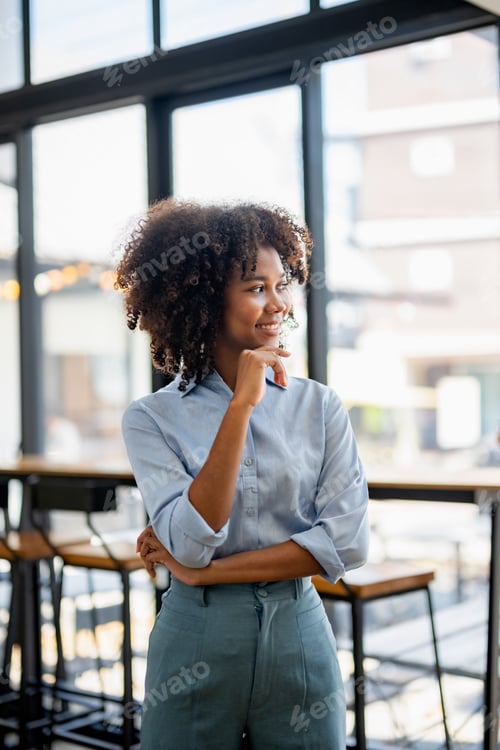 Preview: A woman with curly hair is standing in a restaurant with her arms crossed