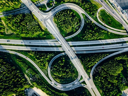 Preview: Aerial view of highway and overpass with green woods in Finland.