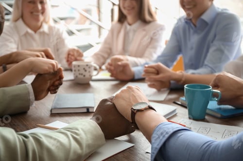Preview: People holding hands together at table. Unity concept