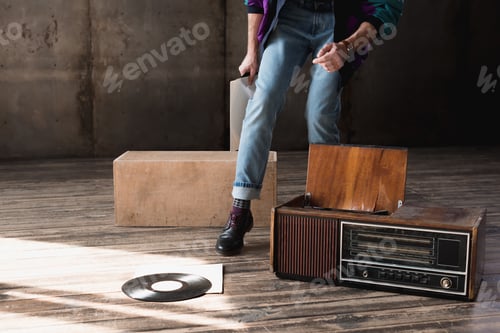 Preview: cropped shot of man in vintage windcheater with vinyl record player