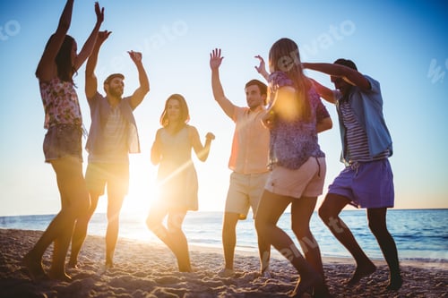 Preview: Happy friends dancing on the sand at the beach