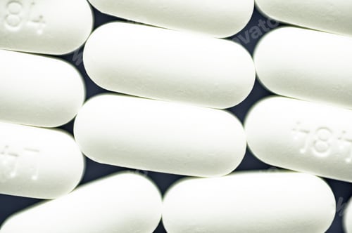 Preview: Closeup shot of white pills on a dark blue surface - the concept of addiction