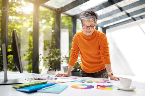 Preview: Stylish mature lady clothing designer using computer