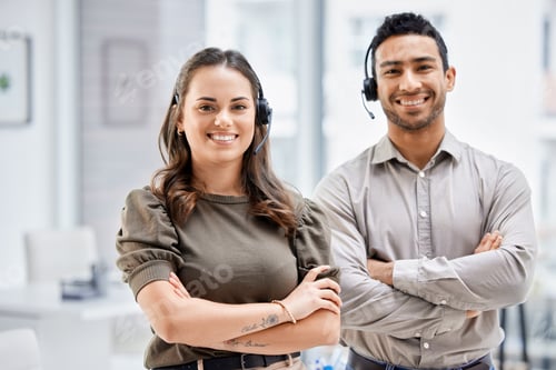 Preview: Cropped portrait of two young call center agents standing with their arms folded in the office