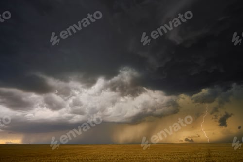 Preview: Dramatic landscape of a stormy sky with lightning striking over a green field in Nebraska Plains,USA