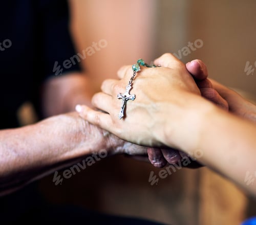 Preview: Cropped shot of a senior woman being comforted by her nurse while holding a rosary