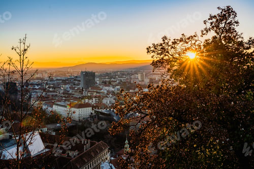 Preview: Golden sunrise over the mountain and city buildings