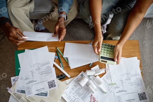 Preview: Young Multiethnic Hands Reviewing Invoices and Calculating Bills Together