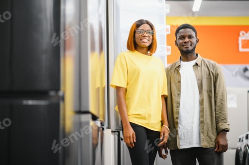 Preview: African american family couple buying domestic refrigerator in supermarket