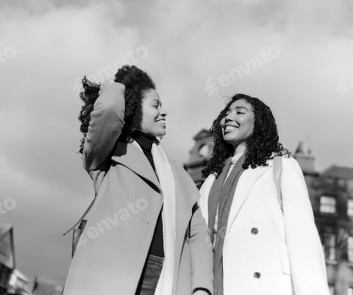 Preview: Two female black friends having fun in analog monochrome portrait.