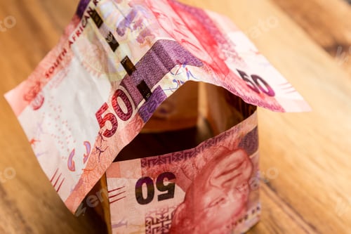 Preview: High angle shot of some South African rand bills on a wooden surface
