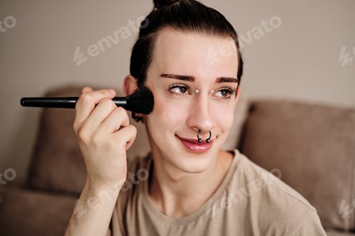 Preview: Cute gay man using make-up brush at home