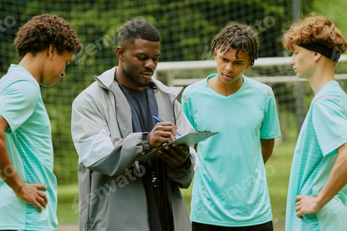 Preview: Young Adult Black Man Coaching Diverse Teenagers during Outdoor Soccer Training