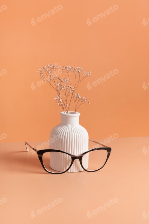 Preview: Eyeglasses with vase on colored background. Optical store, vision test, stylish glasses concept
