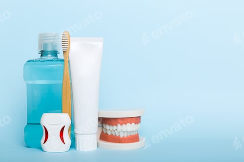 Preview: Mouthwash and other oral hygiene products on colored table top view with copy space