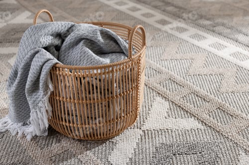 Preview: Wicker basket with gray blanket in living room, space for text