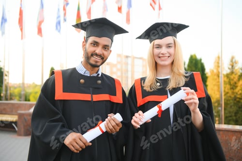 Preview: happy international students in mortar boards and bachelor gowns.