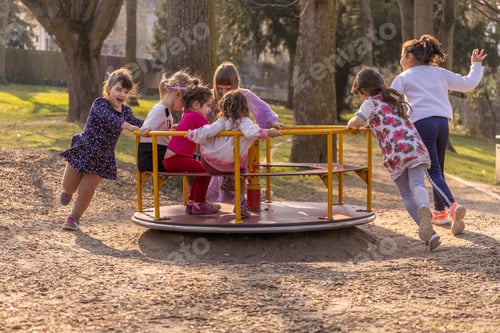 Preview: a company of children having fun together on the playground, children's fun, carousel