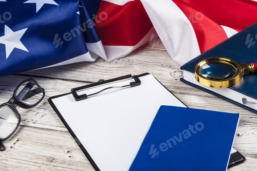 Preview: blank clip board and USA flag on wooden background