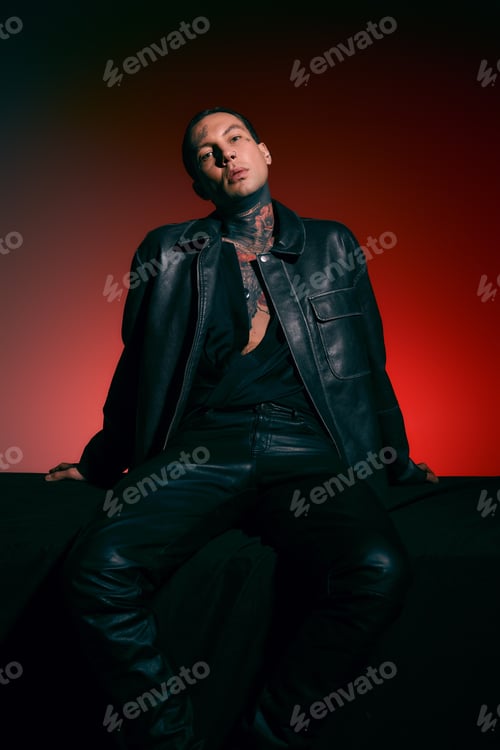 Preview: Handsome stylish man poses confidently in leather attire against a vibrant backdrop