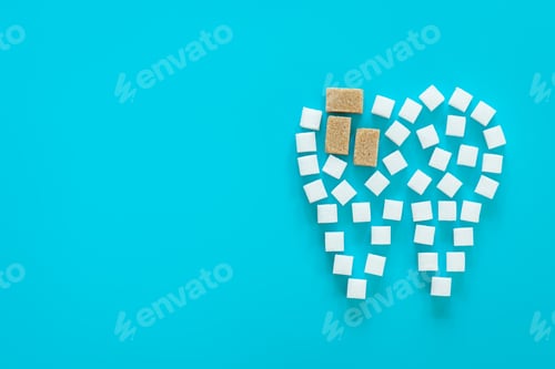 Preview: Flat lay, tooth made of sugar on a blue background.