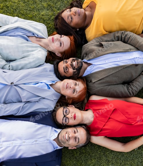 Preview: Group of businesspeople lying down in the grass